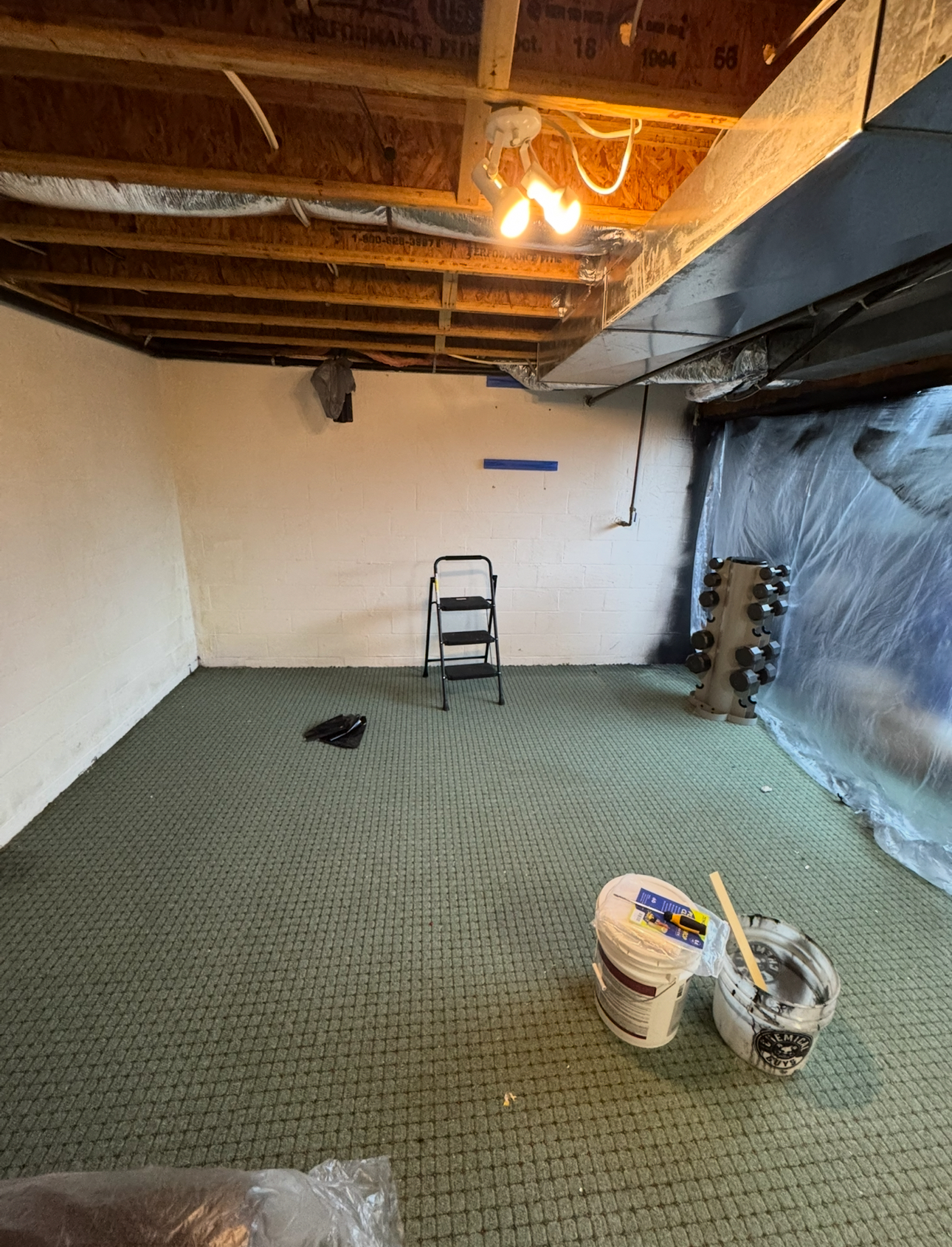Unfinished basement before renovation with exposed walls and concrete floor